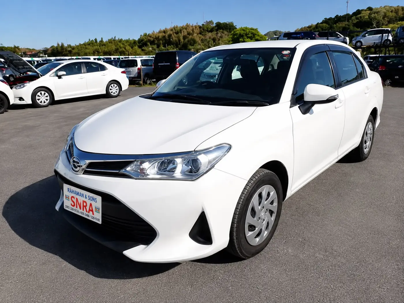 A white Toyota Corolla Axio wearing a Rahaman & Sons trade plate